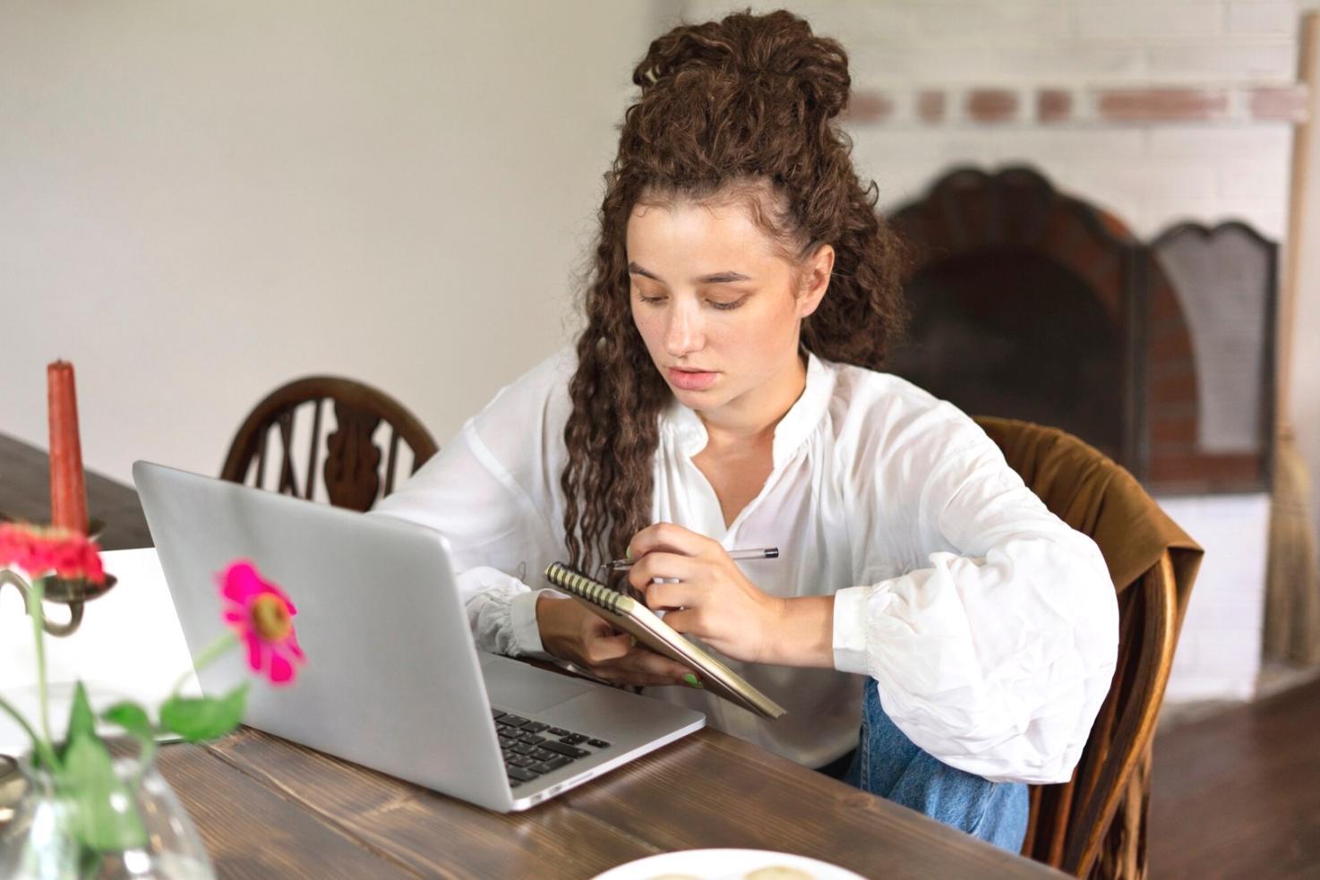 Student analyzing stock charts and taking notes during trading education session